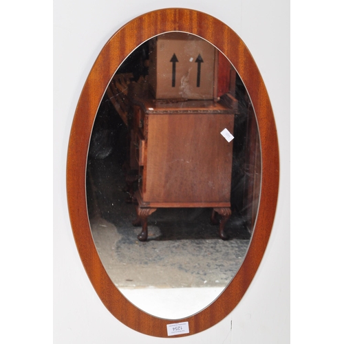 1254 - A retro vintage mid 20th Century teak wall hanging mirror. Of oval form with mirror mounted on a tea... 