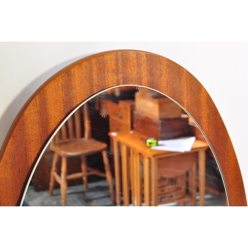 1254 - A retro vintage mid 20th Century teak wall hanging mirror. Of oval form with mirror mounted on a tea... 