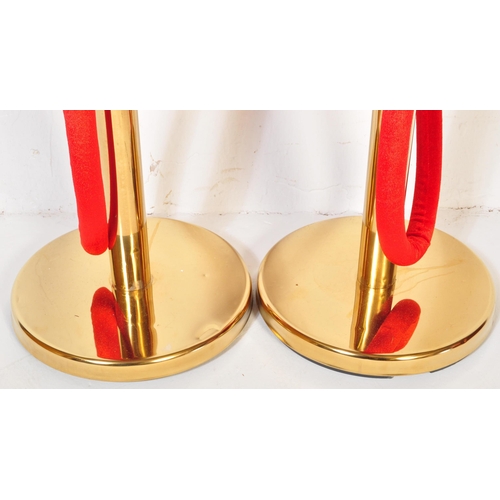 1286 - A pair of contemporary gilt metal pedestal rope barriers having single red rope across on circular p... 