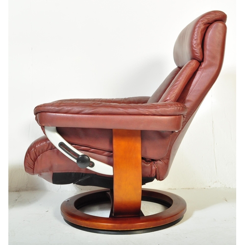 1289 - A vintage 20th Century burgundy leather reclining swivel armchair. With head rest to top straight ar... 