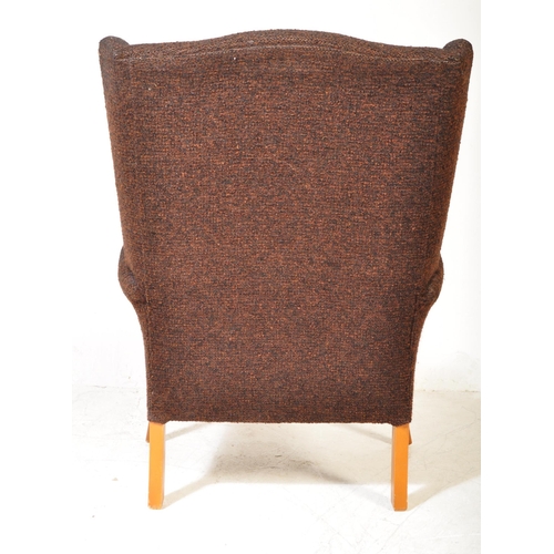 1315 - Mid-century upholstered armchair in the manner of Parker Knoll. Raised on tapering legs with stretch... 