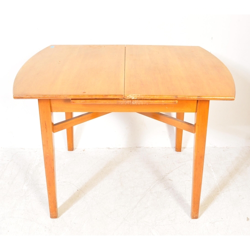 1319 - A vintage retro mid 20th century teak wood extending dining table having oval top over tapering squa... 