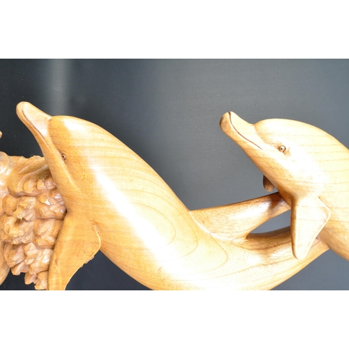 1324 - A vintage 20th Century carved wood sculpture of dolphins. Depicting dolphins swimming with coral ree... 