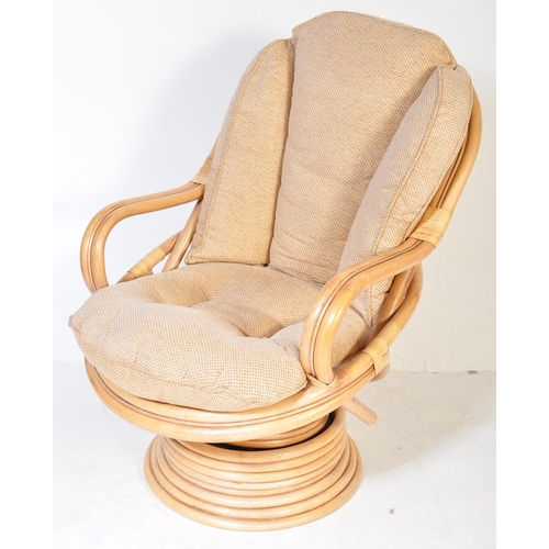 1329 - A retro 20th Century bamboo and wicker / cane swivel armchair / egg chair having a curved backrest w... 