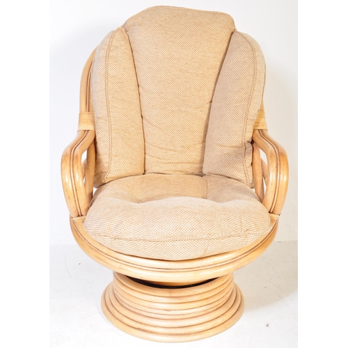 1329 - A retro 20th Century bamboo and wicker / cane swivel armchair / egg chair having a curved backrest w... 