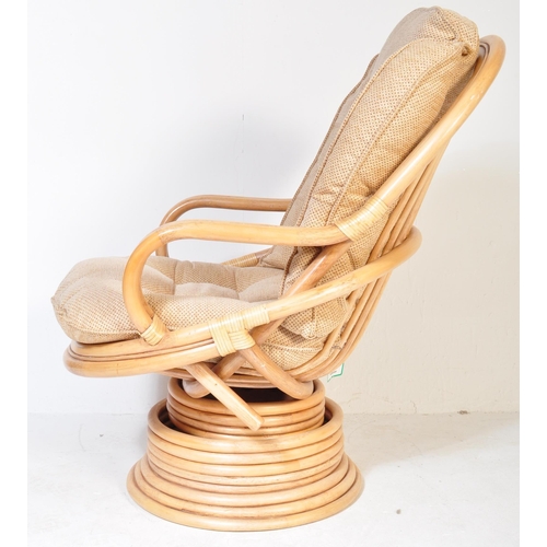 1329 - A retro 20th Century bamboo and wicker / cane swivel armchair / egg chair having a curved backrest w... 