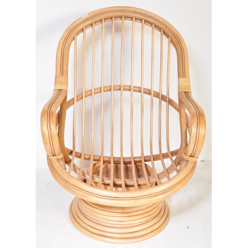 1329 - A retro 20th Century bamboo and wicker / cane swivel armchair / egg chair having a curved backrest w... 