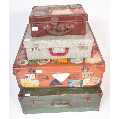 1369 - A stack of four vintage retro 20th century leather travel suitcases in a variety of sizes and colour... 