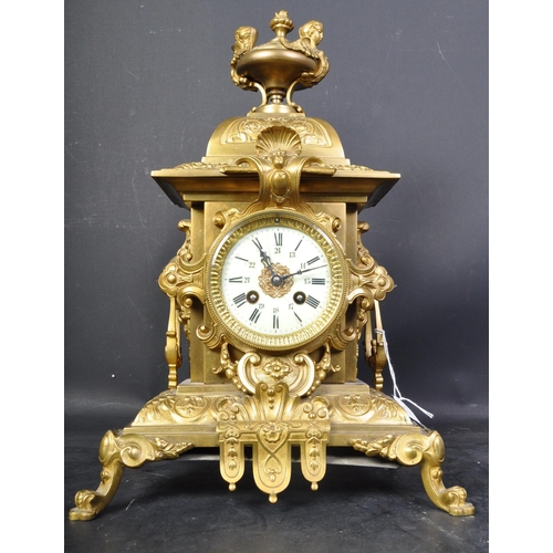 1475 - A 20th century French Louis XIV style gilt brass table mantel clock having a top finial with harpies... 