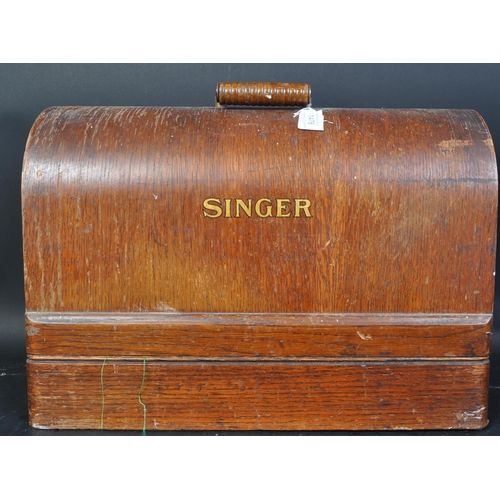 1476 - An early 20th century oak cased Singer ebonised & gilt sewing machine. Serial number Y8093800. The c... 