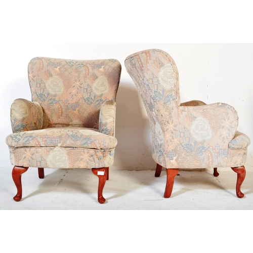 1479 - A pair of mid Century retro armchairs in the Queen Anne revival manner being raised on cabriole legs... 