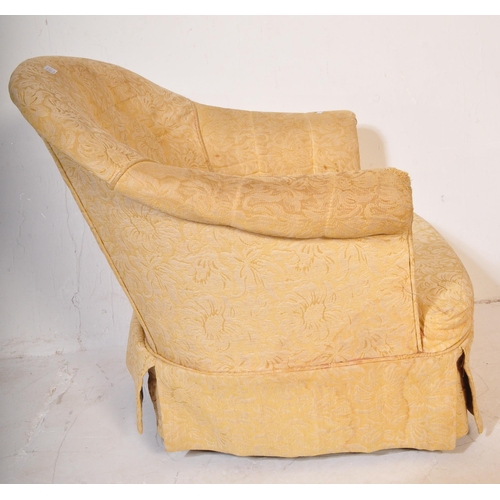 1491 - An early 20th century tub chair / arm chair upholstered in a yellow floral fabric. The chair having ... 