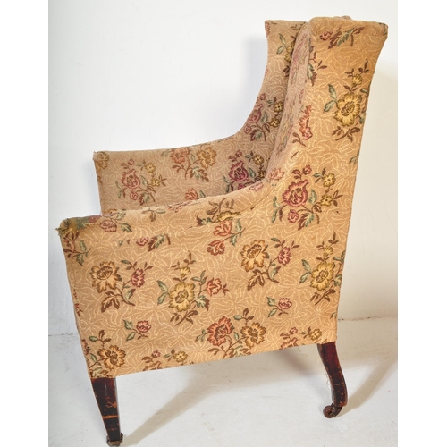 1493 - An Edwardian mahogany wingback armchair having crested swan neck to back rest over sloping elbow res... 