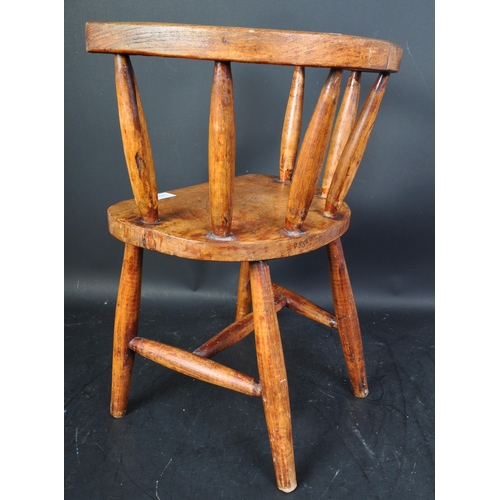 1495 - A early 20th Century elm wood children's chair stool. Having a horseshoe back, with spindles on an o... 