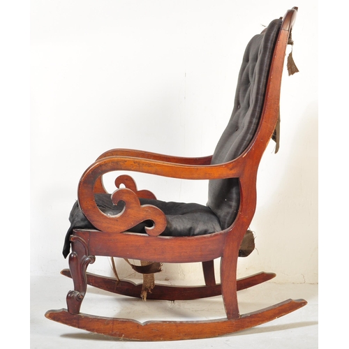 1523 - A 19th Century Victorian mahogany rocking arm chair. Having a long back rest with scrolled decoratio... 