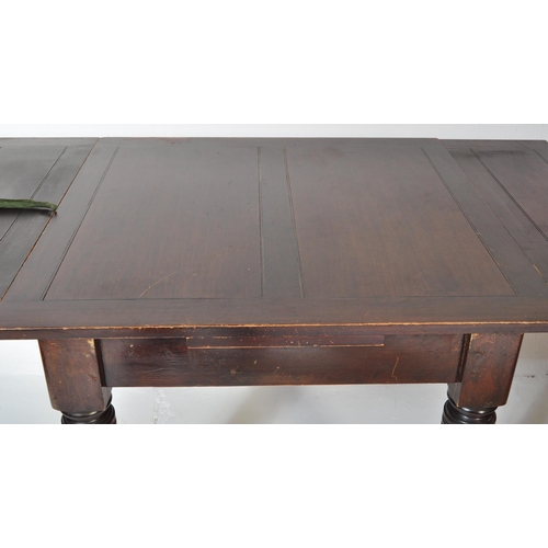 1551 - A 1930's mahogany draw leaf refectory dining table being raised on baluster reeded legs with castors... 