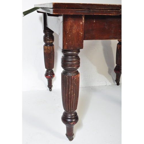 1551 - A 1930's mahogany draw leaf refectory dining table being raised on baluster reeded legs with castors... 