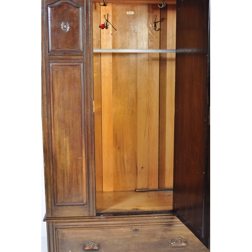 1555 - An Edwardian mahogany arts & crafts single wardrobe armoire. Raised on a plinth drawer base with ova... 