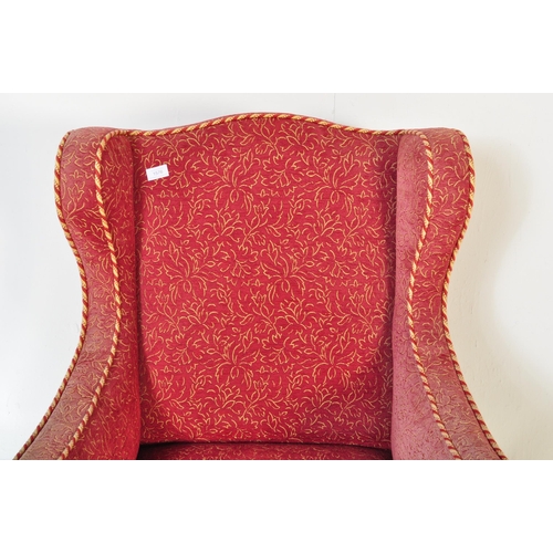 1576 - A Victorian 19th century wingback armchair. The armchair being having curved armrests with brocade t... 