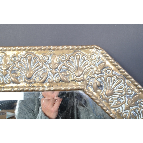 1603 - A Victorian late 19th century Art Nouveau repousse brass mirror of canted rectangular form with foli... 