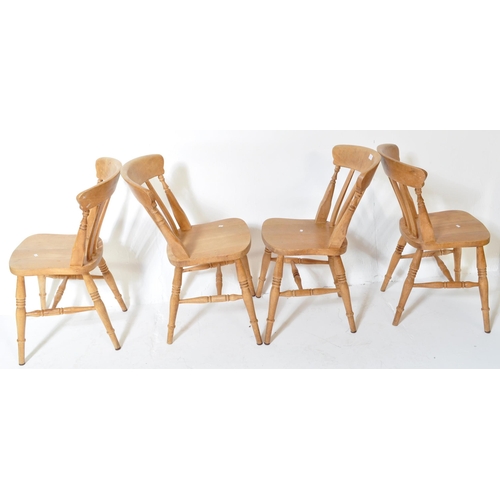 1610 - A set of four Victorian style pine farmhouse Windsor dining chairs. Having a curved backrest with ho... 