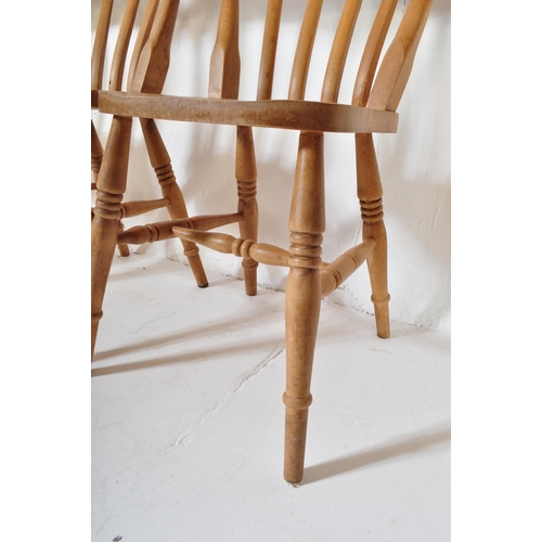 1610 - A set of four Victorian style pine farmhouse Windsor dining chairs. Having a curved backrest with ho... 