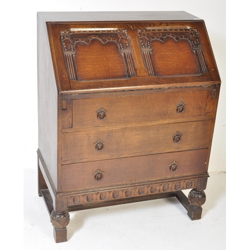 1619 - A 20th century Jacobean revival oak bureau desk. The bureau being raised on cup and cover carved leg... 