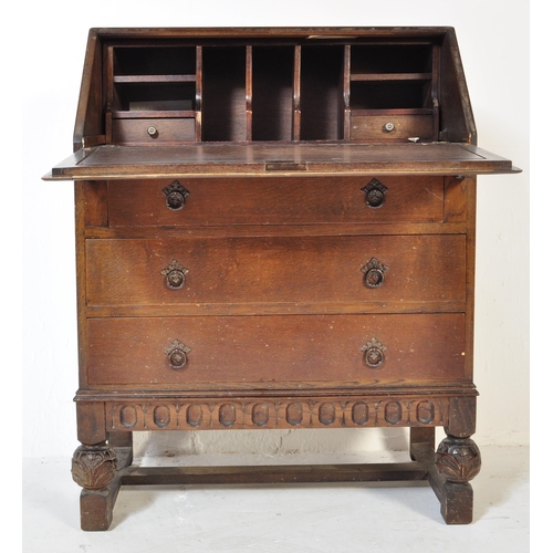 1619 - A 20th century Jacobean revival oak bureau desk. The bureau being raised on cup and cover carved leg... 