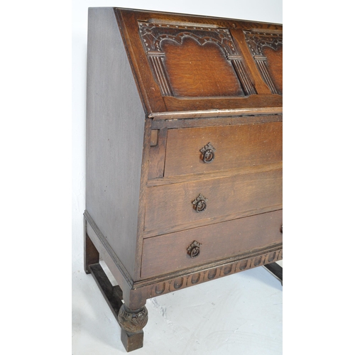 1619 - A 20th century Jacobean revival oak bureau desk. The bureau being raised on cup and cover carved leg... 