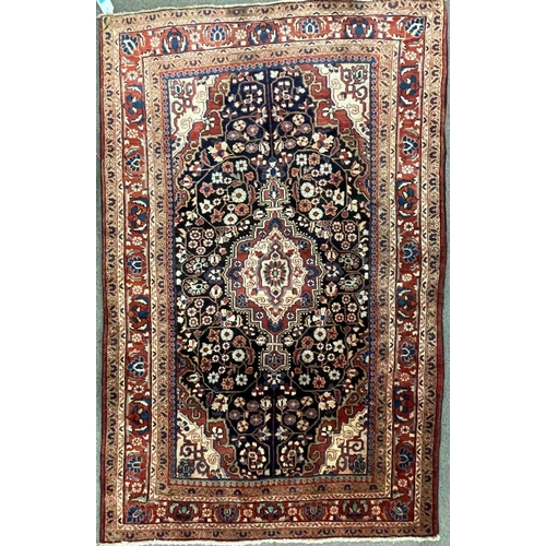 1819 - An early 20th century Persian Islamic North West Sarouk floor carpet rug having a central medallion ... 