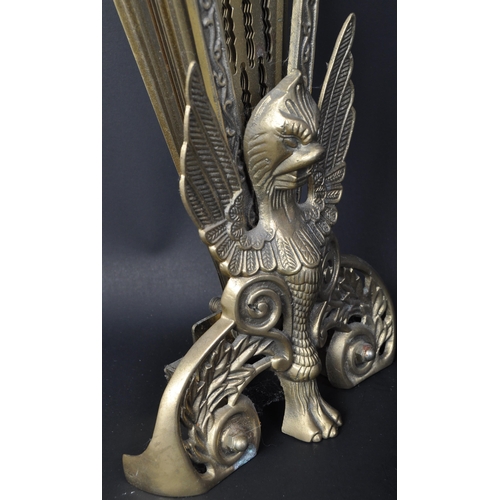 1573 - An early 20th century brass extending peacock fireguard having moulded griffin figure to centre with... 