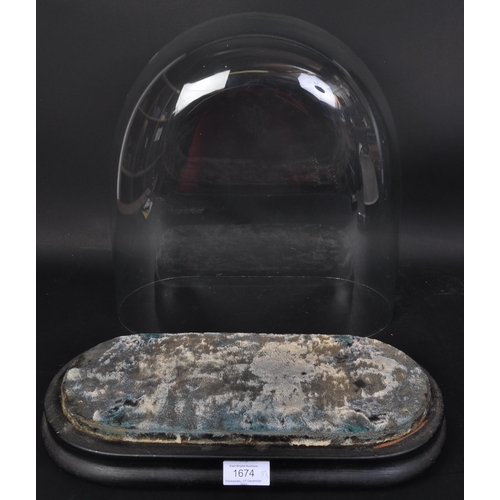 1674 - A large 19th century Victorian glass domed display case. On an oval curved ebonised base with thin v... 