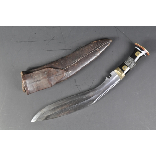 11 - A vintage Nepalese / Gurkha Regiment Kukri knife dagger. The knife having a brass capped pommel with... 