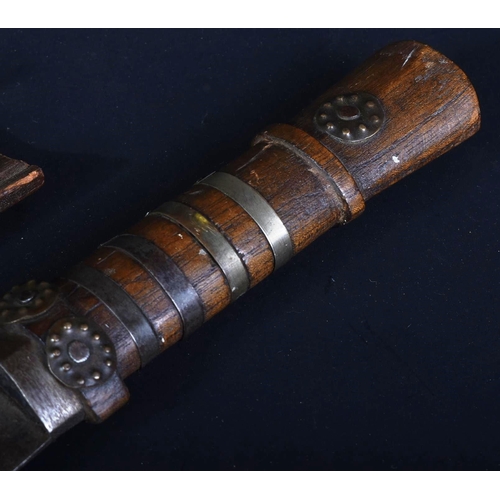 221 - A 19th Century Bhutanese ethnic knife / dagger with wooden grip and sectioned brass collars. The wid... 