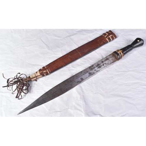 287 - An early 20th Century North African / Sudanese tribal sword. Leather grip over a wooden core and a f... 