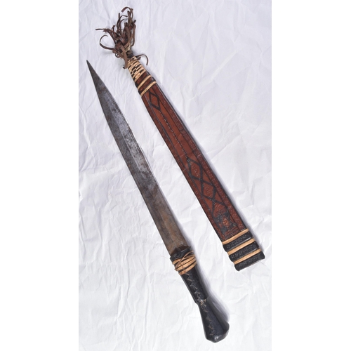 287 - An early 20th Century North African / Sudanese tribal sword. Leather grip over a wooden core and a f... 