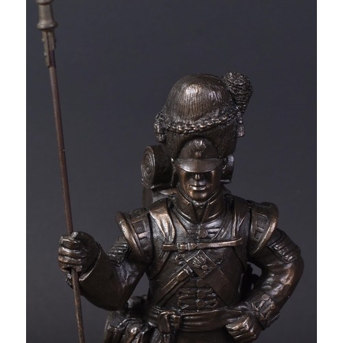 319 - A mid 20th Century bronzed figurine depicting a Royal Welsh Fusiliers Infantry soldier. The soldier ... 