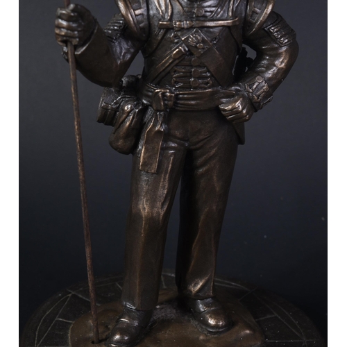 319 - A mid 20th Century bronzed figurine depicting a Royal Welsh Fusiliers Infantry soldier. The soldier ... 