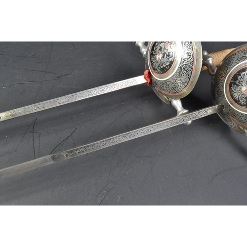 92 - A pair of 20th Century Spanish fencing sword foils with Toledo blades. The foils having urn shaped p... 