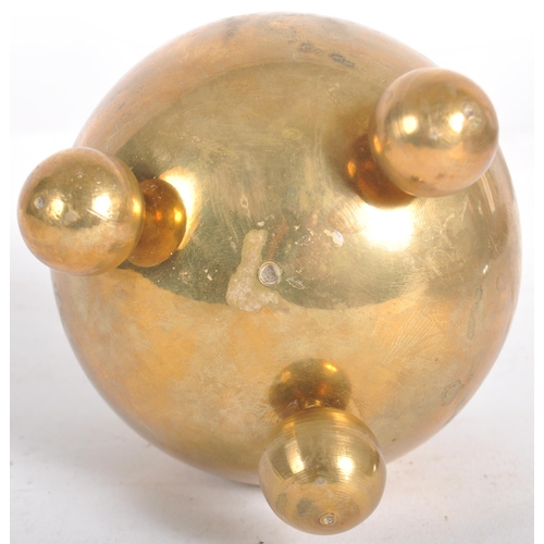 111 - A retro mid 20th Century designer brass candlestick holder having a lipped rim over a spherical body... 