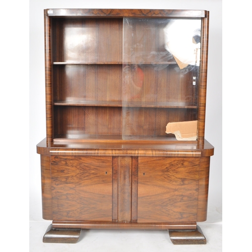 112 - A large vintage 20th Century Art Deco walnut veneer bookcase cabinet having a twin glass sliding doo... 