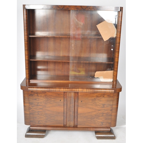 112 - A large vintage 20th Century Art Deco walnut veneer bookcase cabinet having a twin glass sliding doo... 