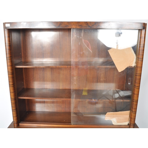 112 - A large vintage 20th Century Art Deco walnut veneer bookcase cabinet having a twin glass sliding doo... 