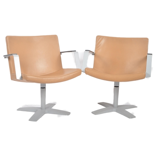 127 - Inno - A matching pair of 20th Century lounge chairs / swivel armchairs. Each having a padded seat a... 