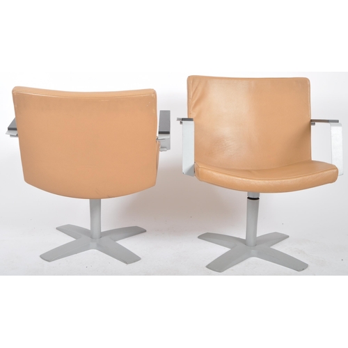 127 - Inno - A matching pair of 20th Century lounge chairs / swivel armchairs. Each having a padded seat a... 