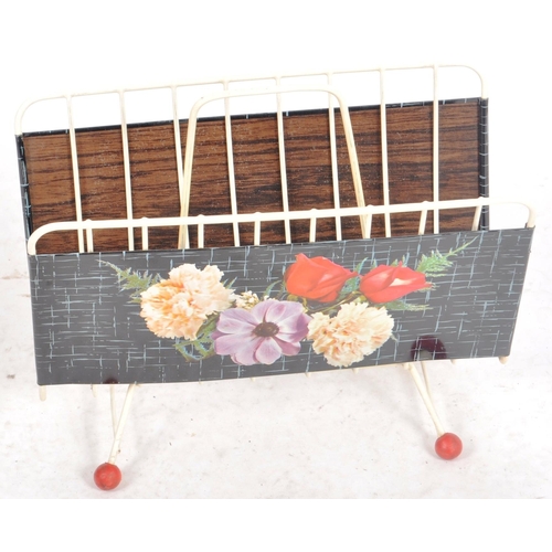 132 - A vintage mid Century 1950s magazine rack having tin panel sides with painted floral features. White... 