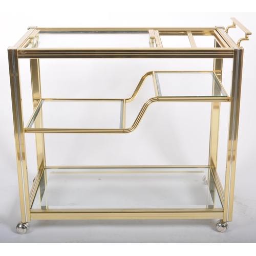 154 - A Contemporary designer brass effect three tier drink / cocktail trolley having a reeded framed with... 