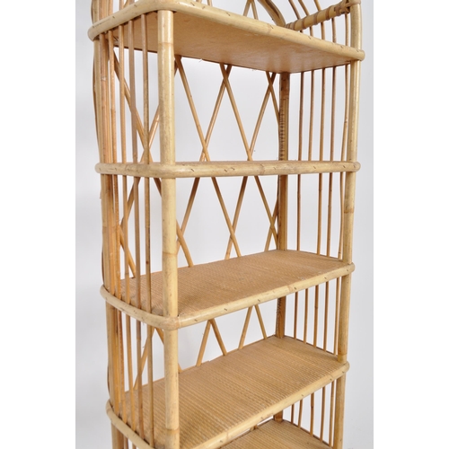 162 - A vintage mid 20th Century bamboo and cane bookcase having an arched top with woven shelves and open... 