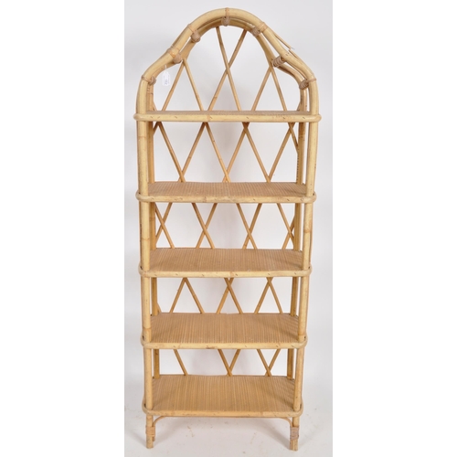 162 - A vintage mid 20th Century bamboo and cane bookcase having an arched top with woven shelves and open... 