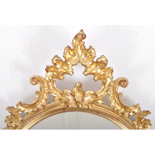 204 - A late 20th Century Hollywood Regency gilt frame pier mirror / hallway mirror having a shaped mirror... 